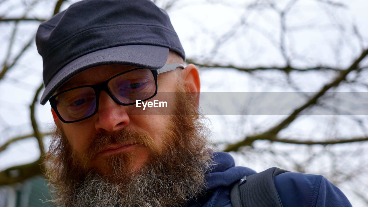 Close-up of bearded man wearing cap and eyeglasses