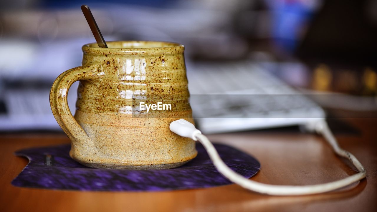 Keyboard cable connected to tea cup on mouse pad