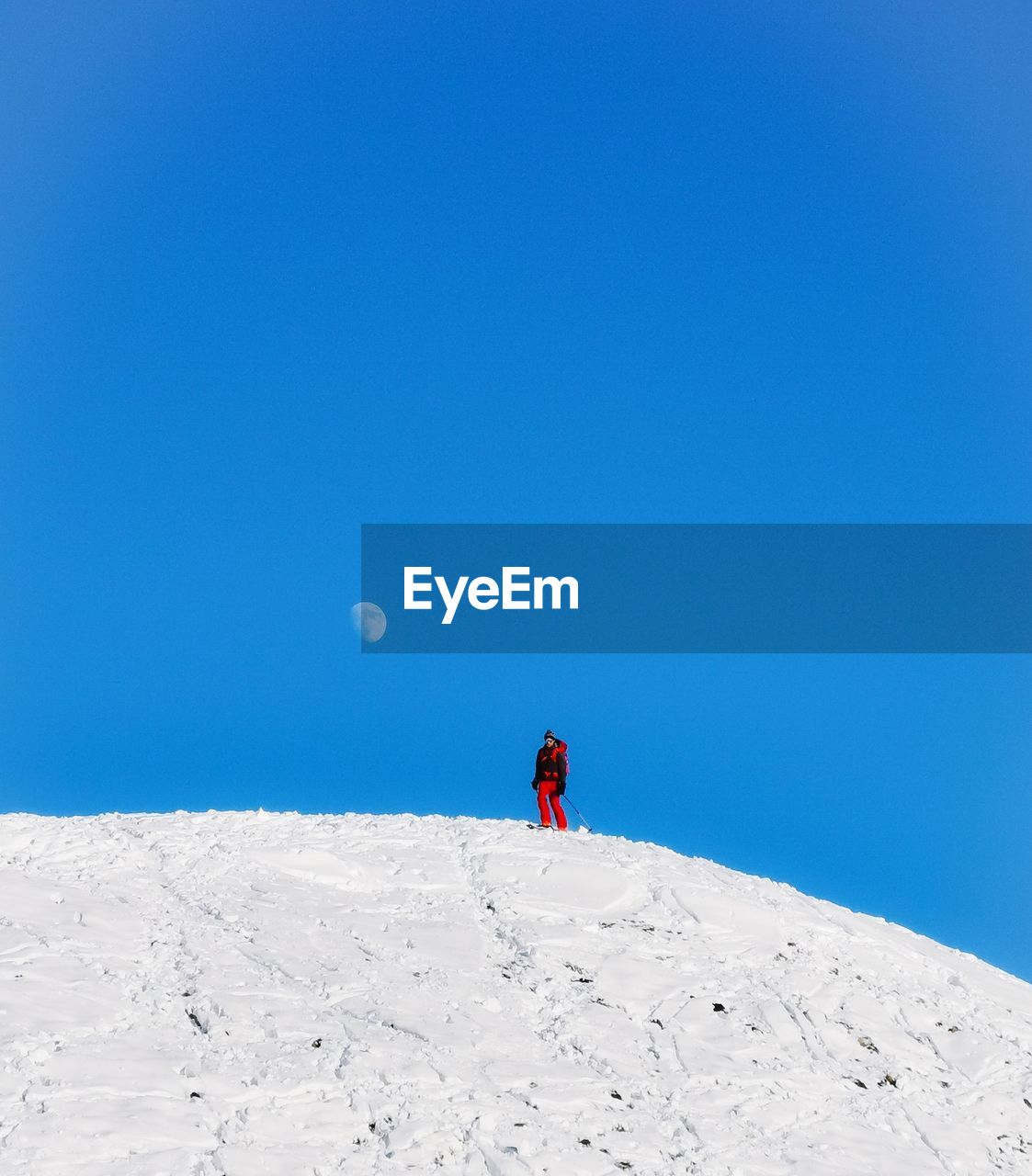 Man on snowcapped mountain against clear blue sky