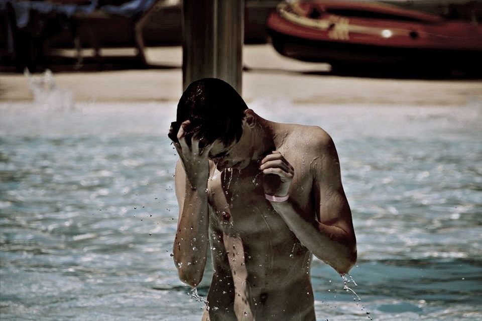 Wet man standing in sea