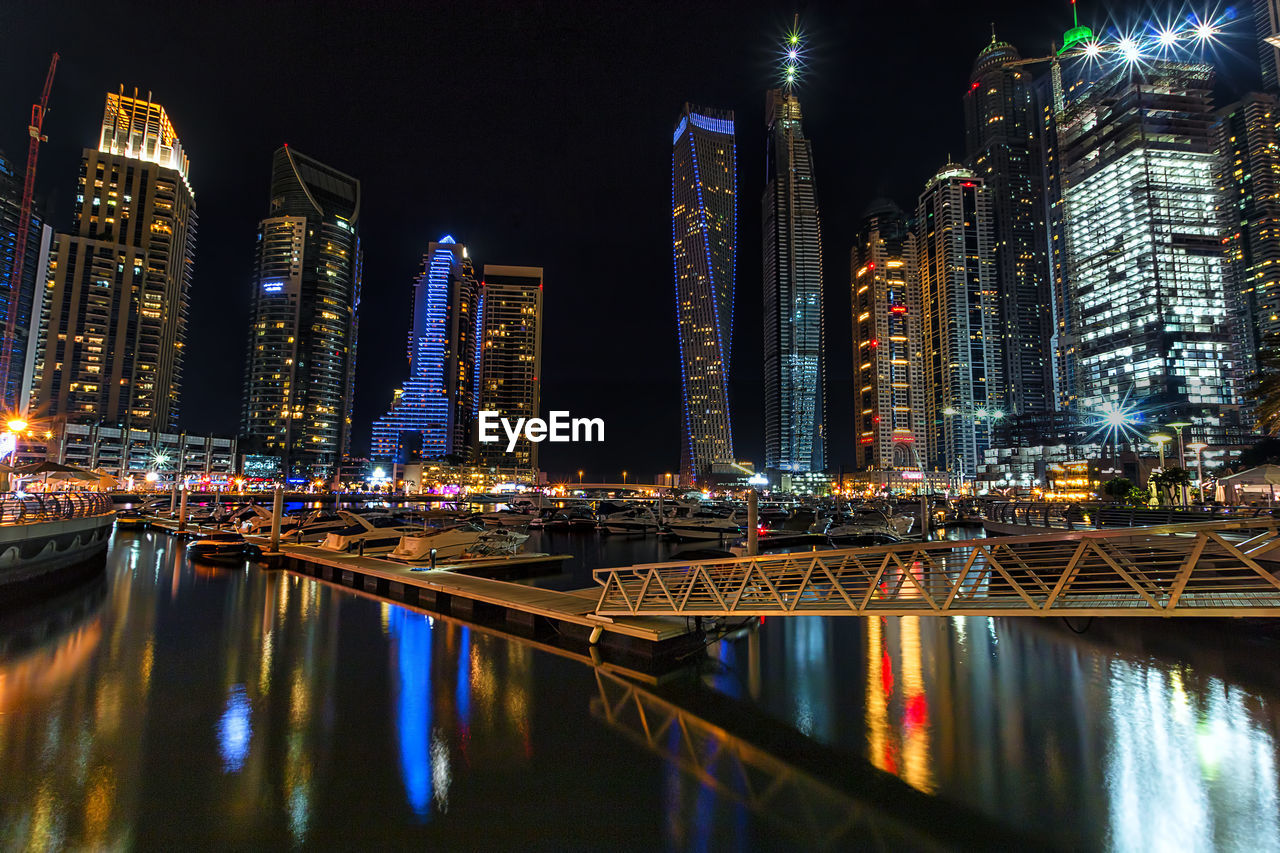 Illuminated modern buildings against sky in city at dubai marina during night