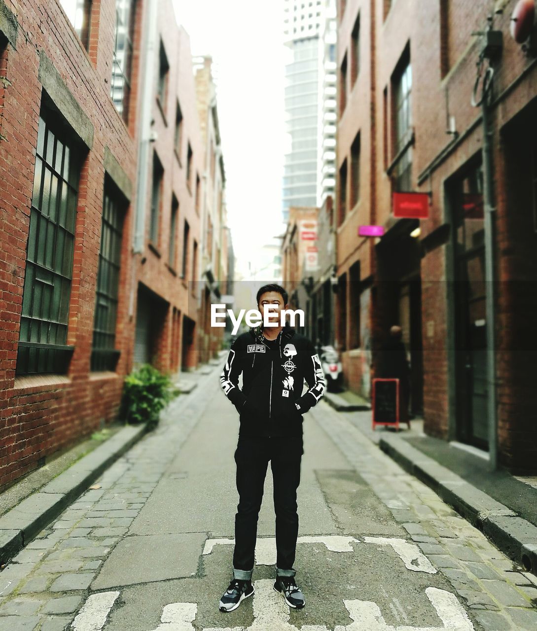 WOMAN STANDING IN FRONT OF BUILDING