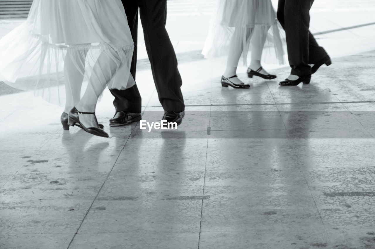 Low section of people dancing on tiled floor