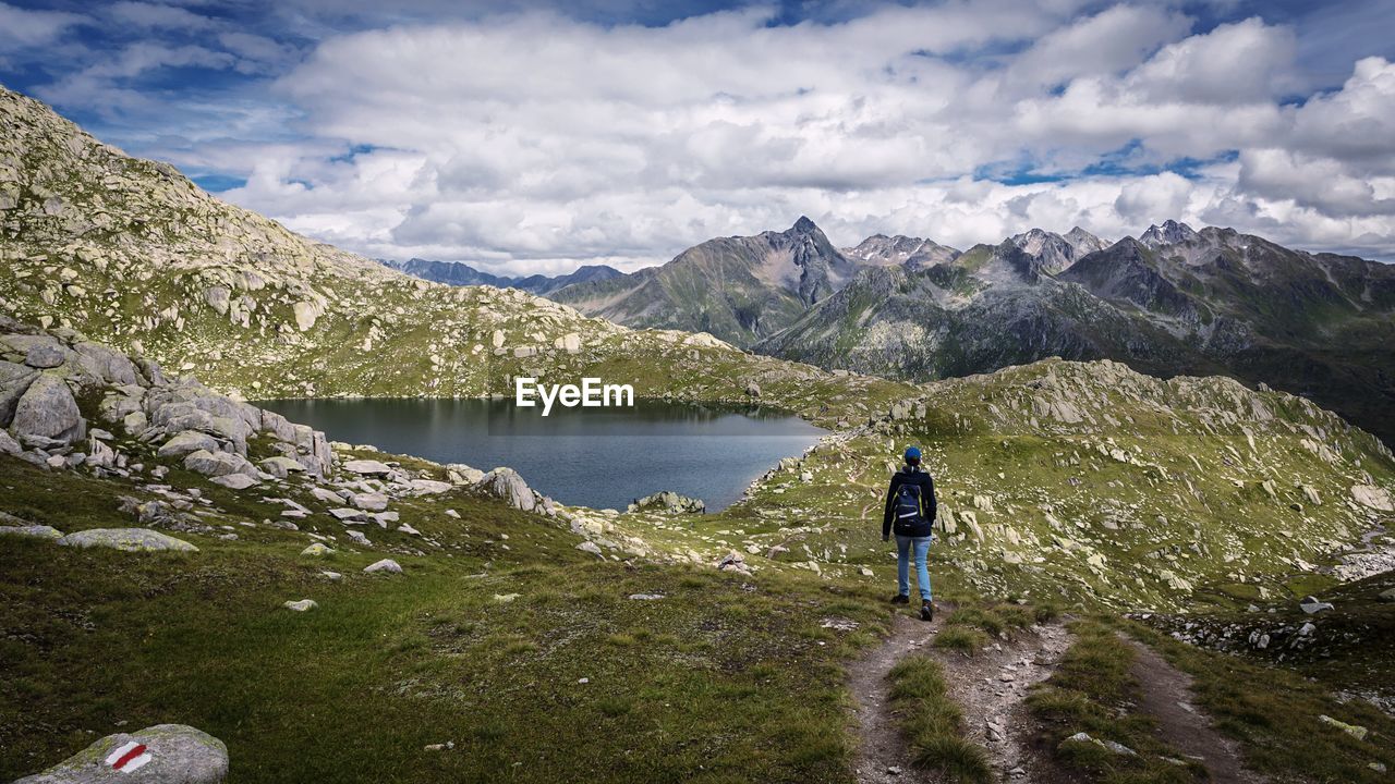 Rear view of woman walking against lake