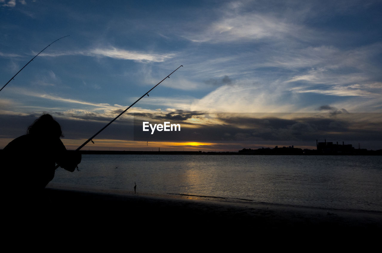 SILHOUETTE MAN FISHING AT SEA AGAINST SKY DURING SUNSET