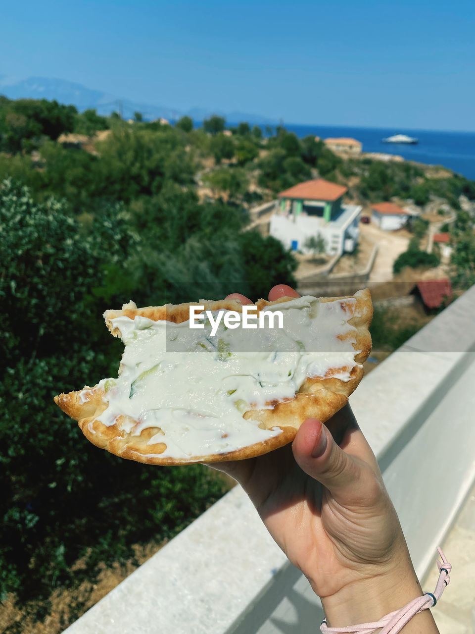 one person, hand, holding, sky, day, nature, food and drink, food, adult, lifestyles, tree, leisure activity, fast food, leaf, personal perspective, focus on foreground, outdoors, water, architecture, plant, travel, sea, close-up, city, high angle view