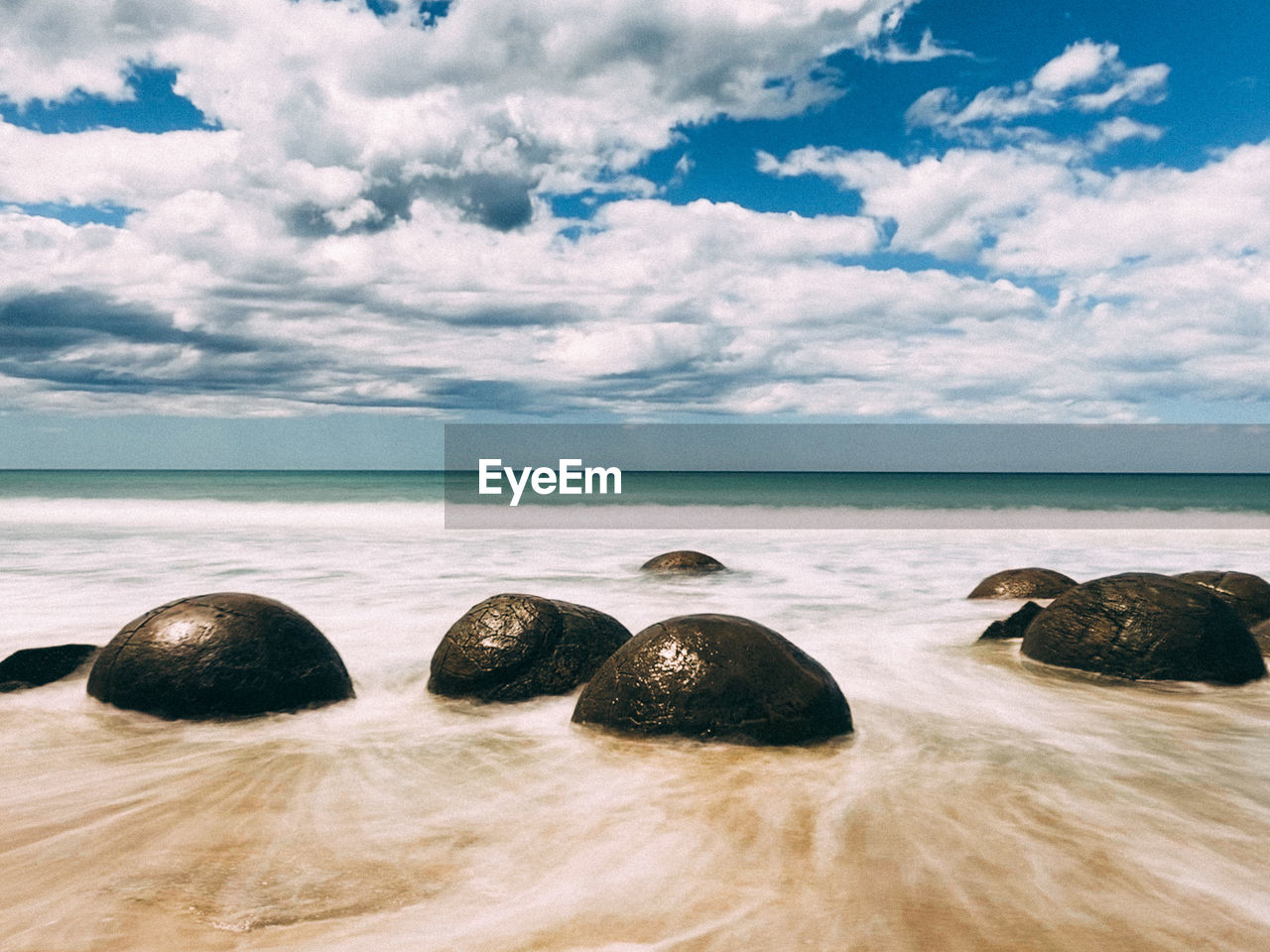 Rocks on beach against sky