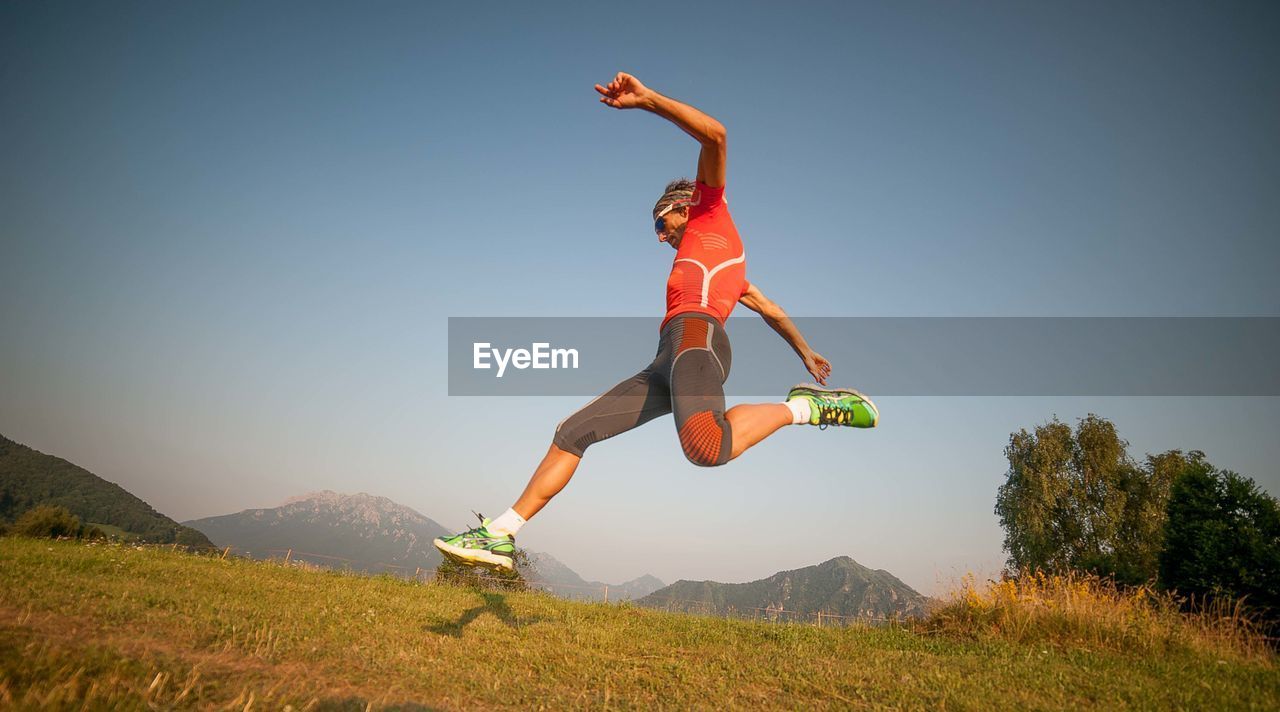 Man jumping in mid-air against sky