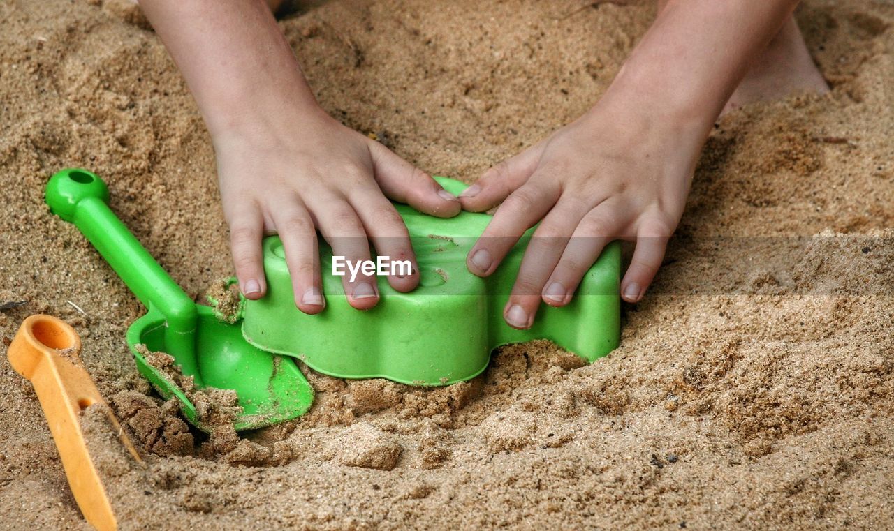 HIGH ANGLE VIEW OF BABY BOY ON SAND