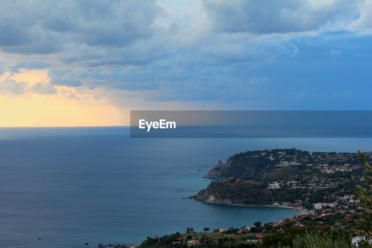 Scenic view of sea by buildings against sky