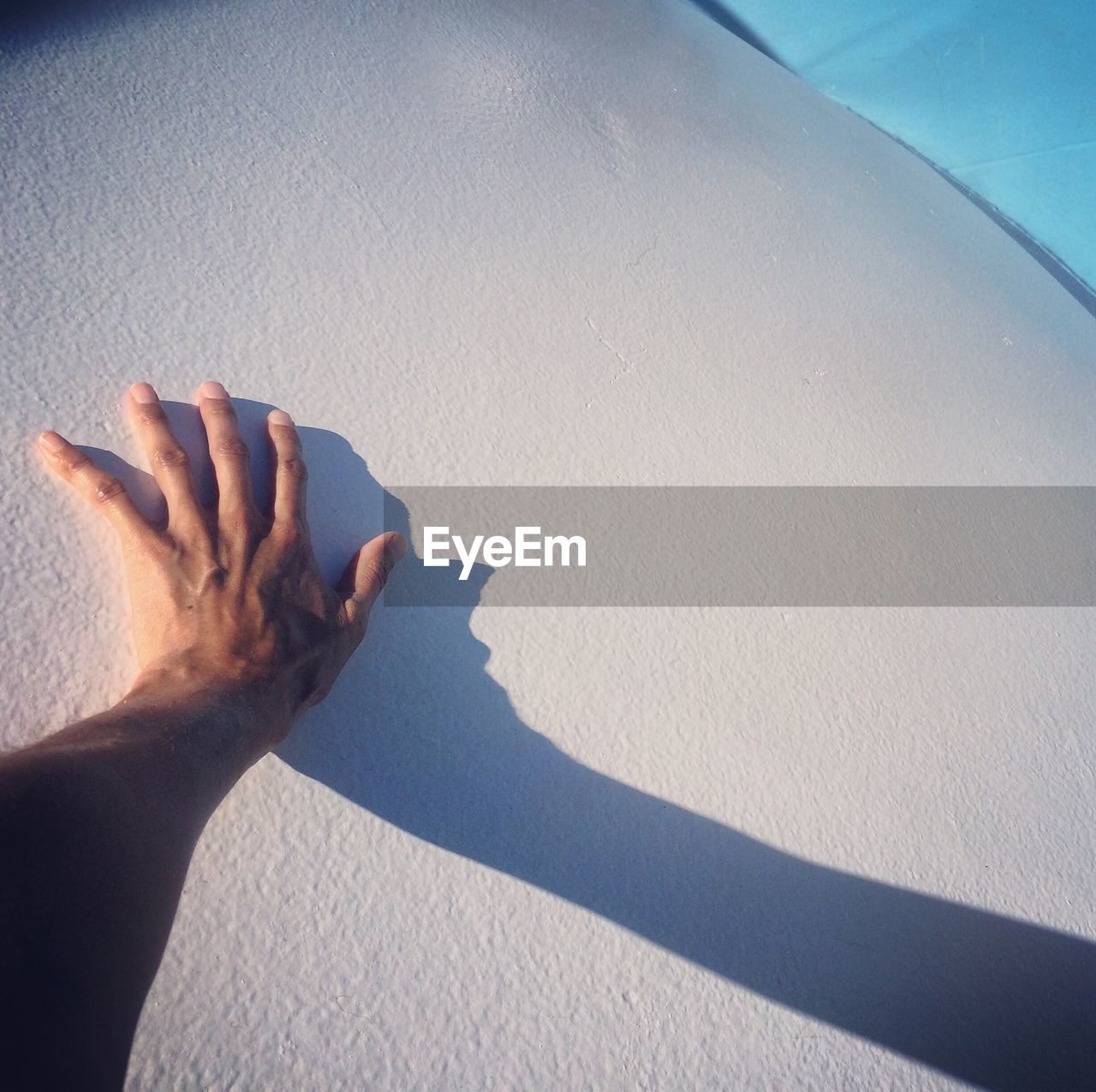 CLOSE-UP OF HAND WITH SHADOW ON SAND