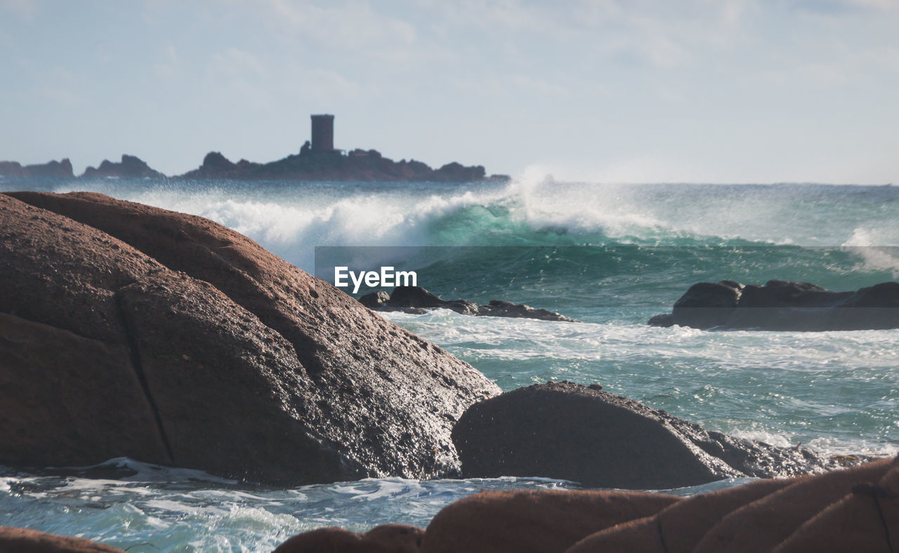 Scenic view of rocks on beach against sky