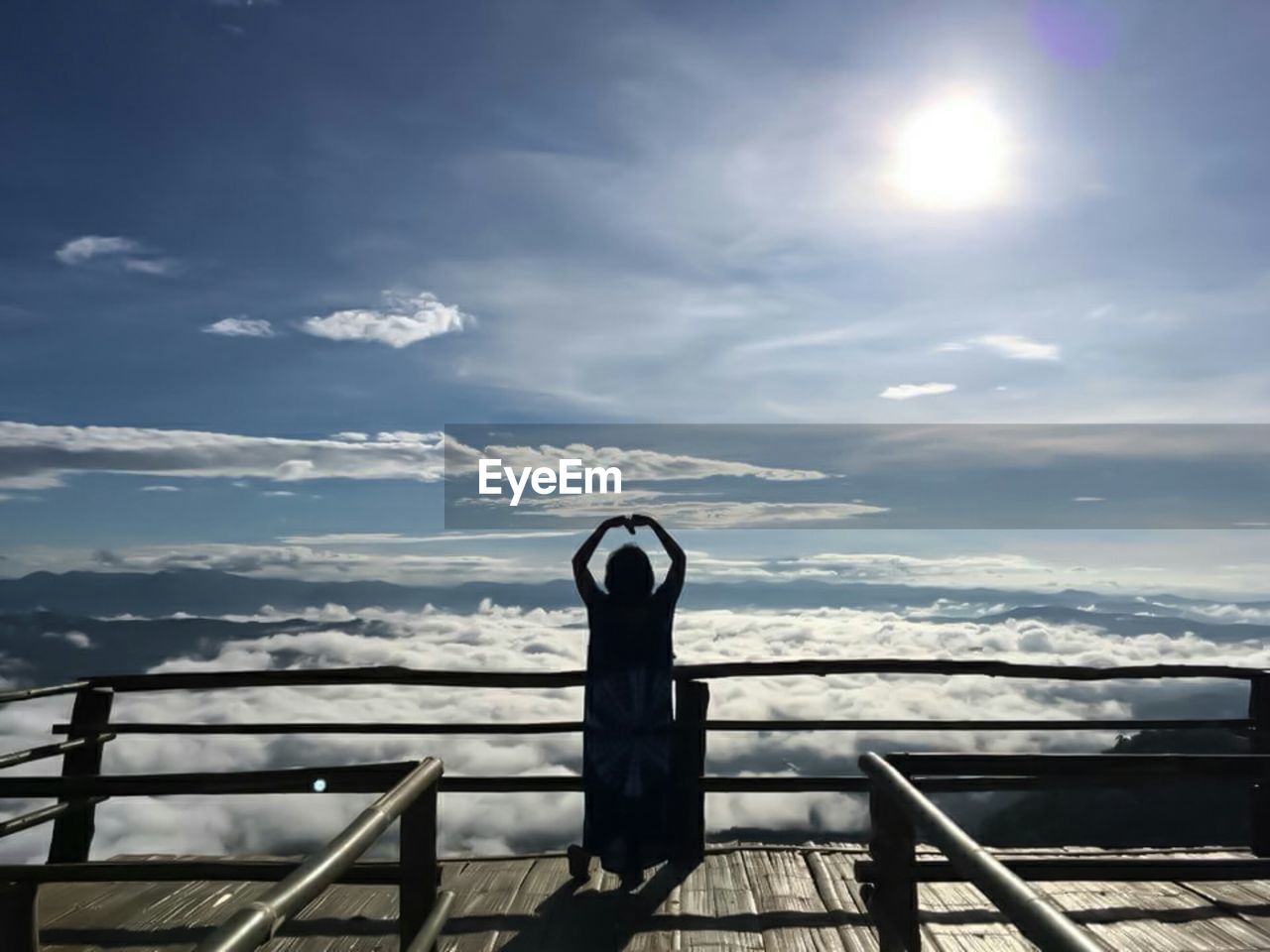 LOW SECTION OF PERSON BY RAILING AGAINST SEA