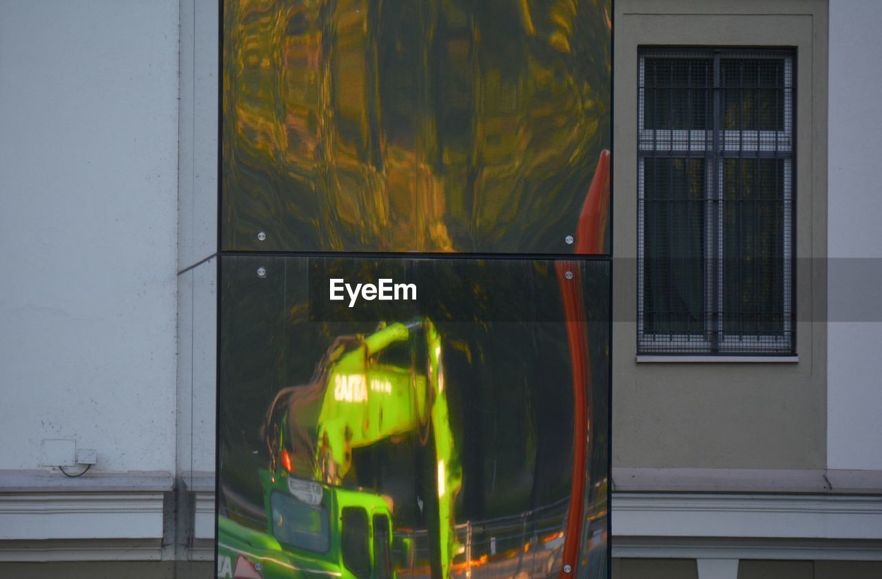 REFLECTION OF HOUSE ON GLASS WINDOW OF BUILDING