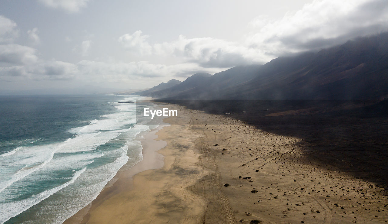 SCENIC VIEW OF BEACH AND MOUNTAINS AGAINST SKY