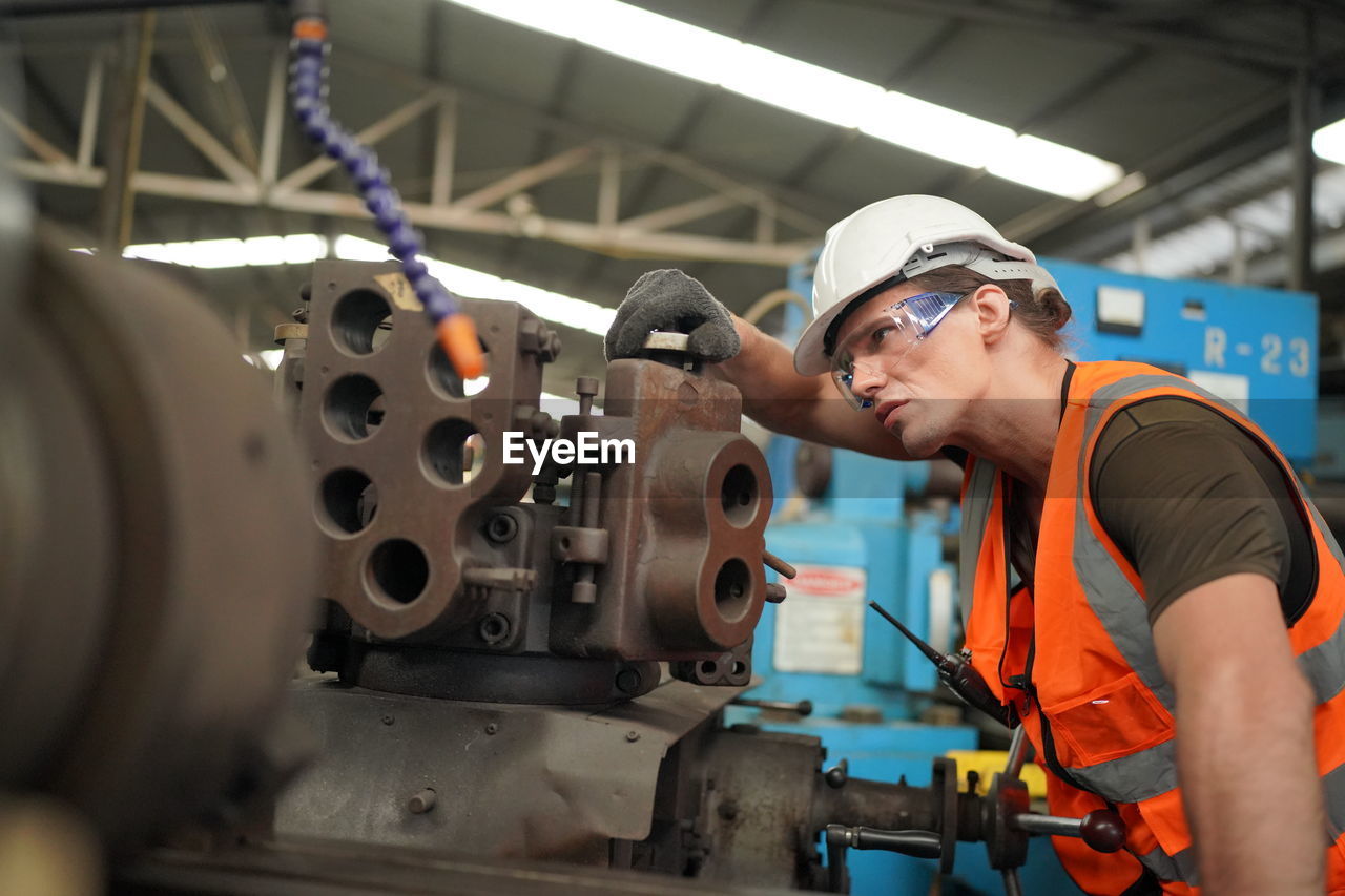 Portrait of male worker standing in the heavy industry manufacturing factory.