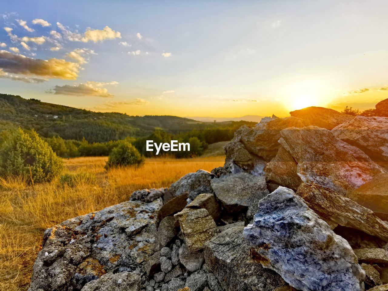 Rocks on land against sky during sunset