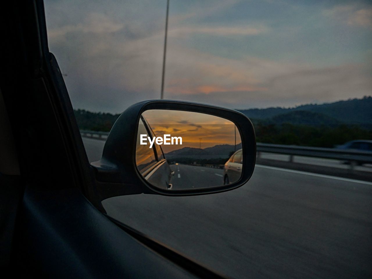 REFLECTION OF CLOUDS IN SIDE-VIEW MIRROR