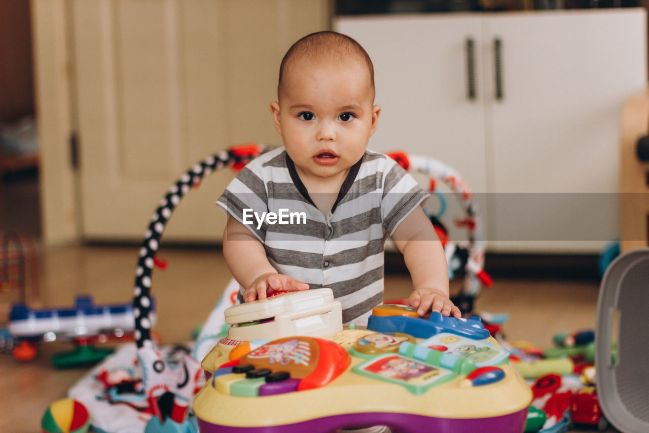 Portrait of cute boy with toy at home