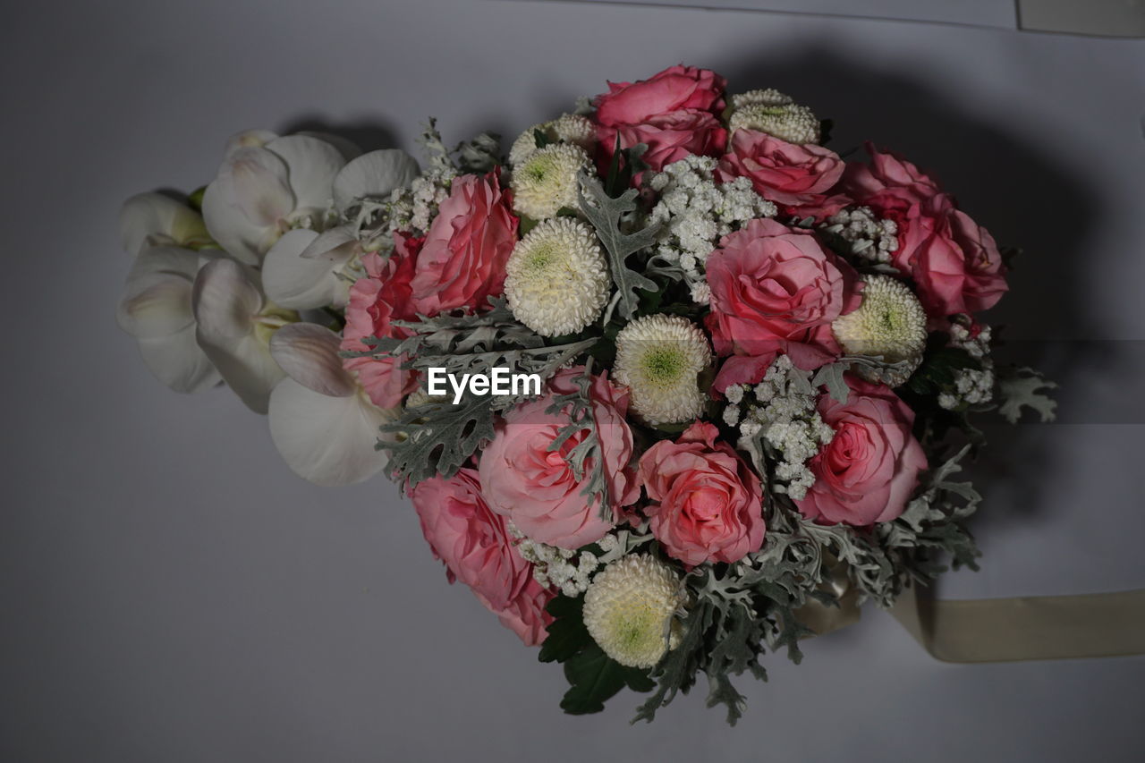 floristry, flower, pink, bouquet, plant, flowering plant, floral design, petal, beauty in nature, freshness, rose, nature, indoors, cut flowers, flower arrangement, arrangement, art, close-up, garden roses, fragility, no people, flower head, red, studio shot, gray background, directly above, bunch of flowers, still life, emotion, centrepiece, gray, high angle view