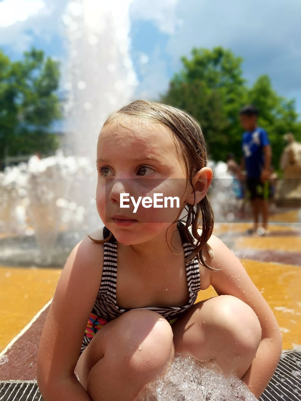 PORTRAIT OF CUTE GIRL SITTING AT SWIMMING POOL