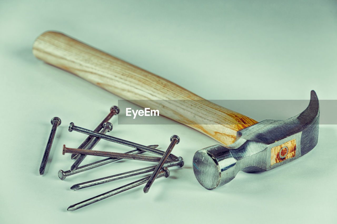 High angle view of hammer and nails on white background