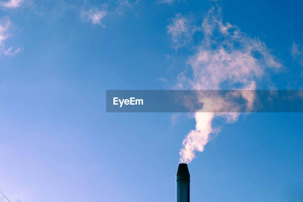 Low angle view of smoke stack against sky