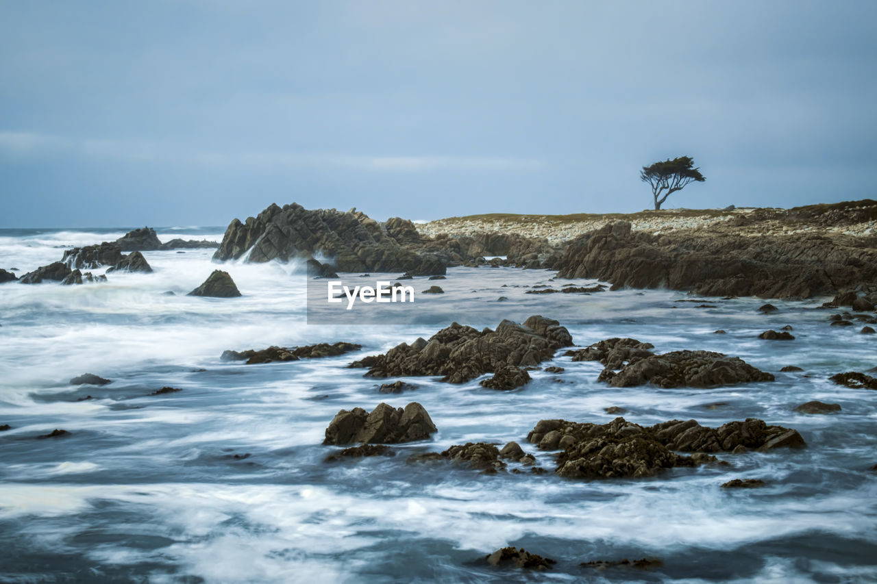 Rocks at beach against sky