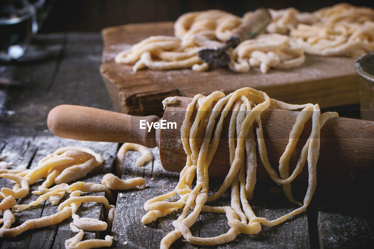 Close-up of dough with rolling pin on table