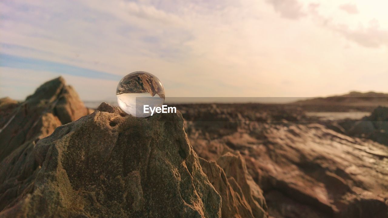 ROCKS ON SHORE AGAINST SKY