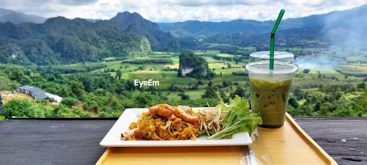 Close-up of thai food and drink on table.