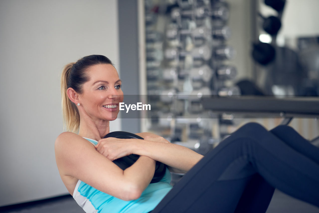 Smiling woman exercising in gym