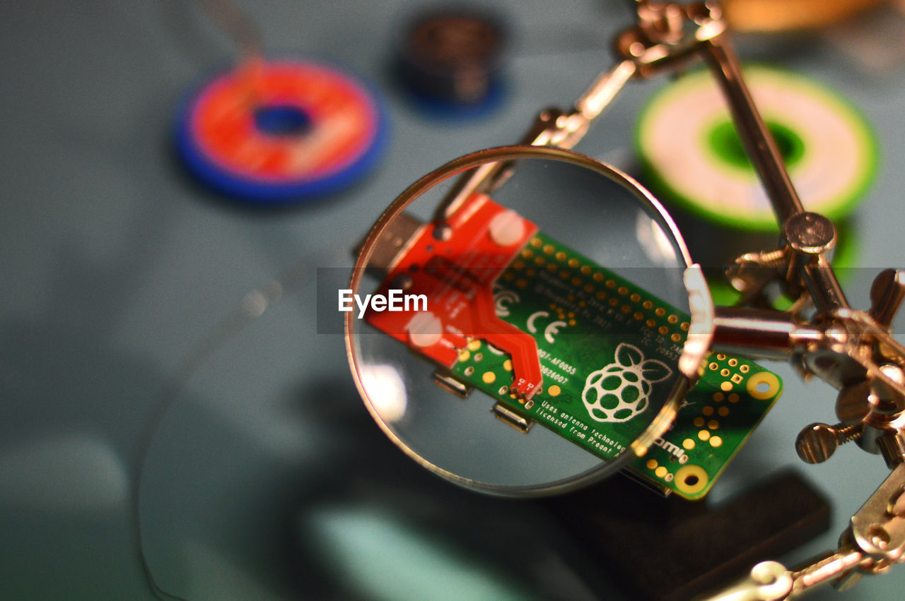 High angle view of magnifying glass and computer chip