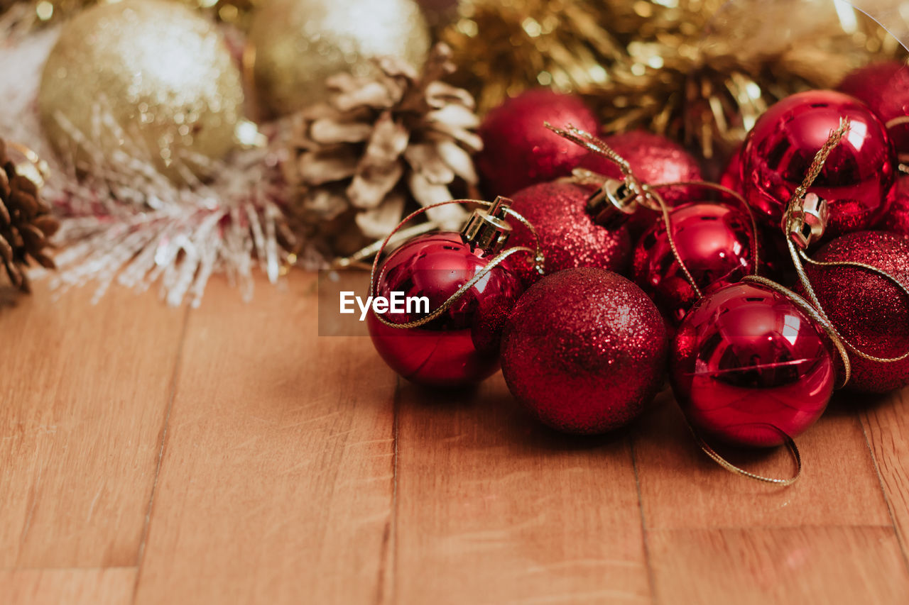 Bunch of shiny red baubles placed on lumber floor on christmas day