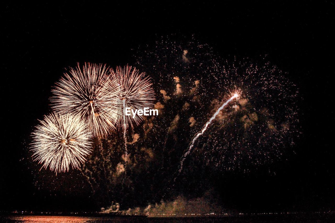 Low angle view of firework display at night