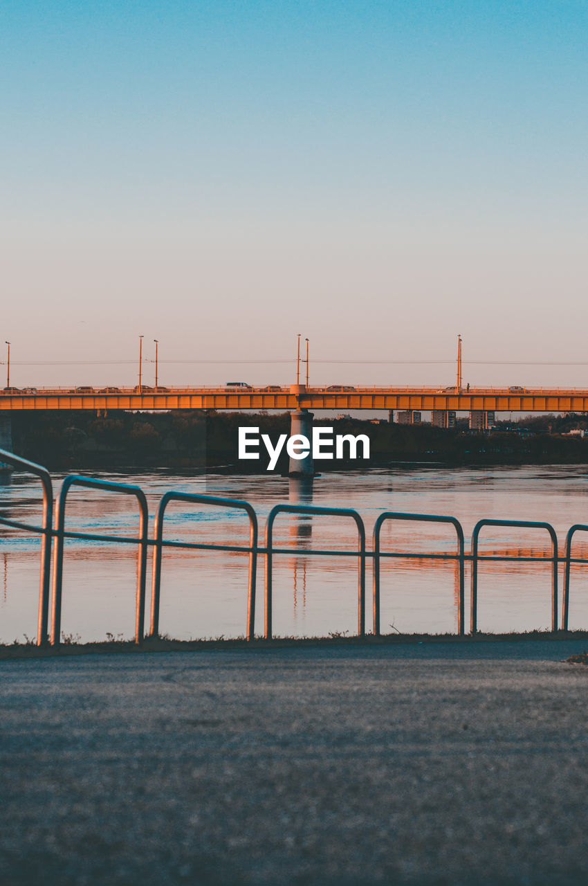 Bridge over sea against clear sky during sunset