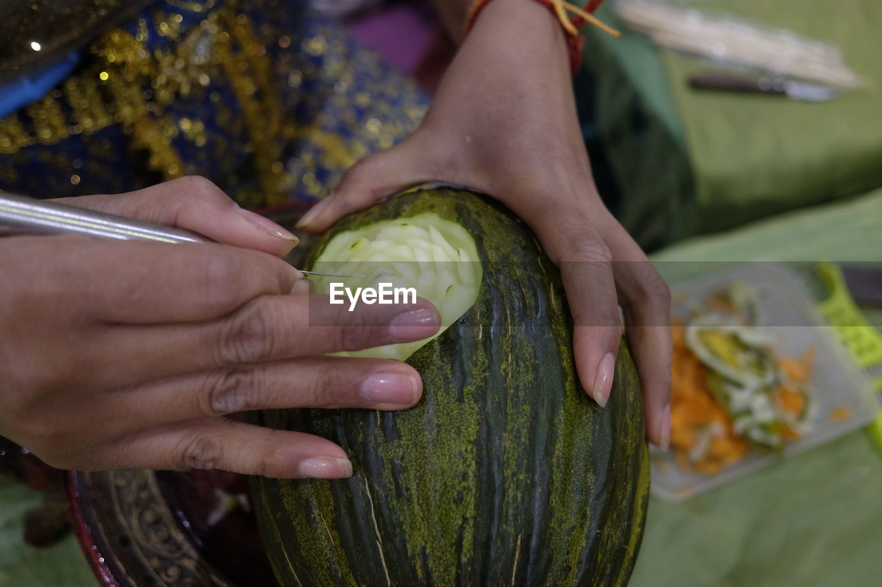 Cropped hands of woman carving on food