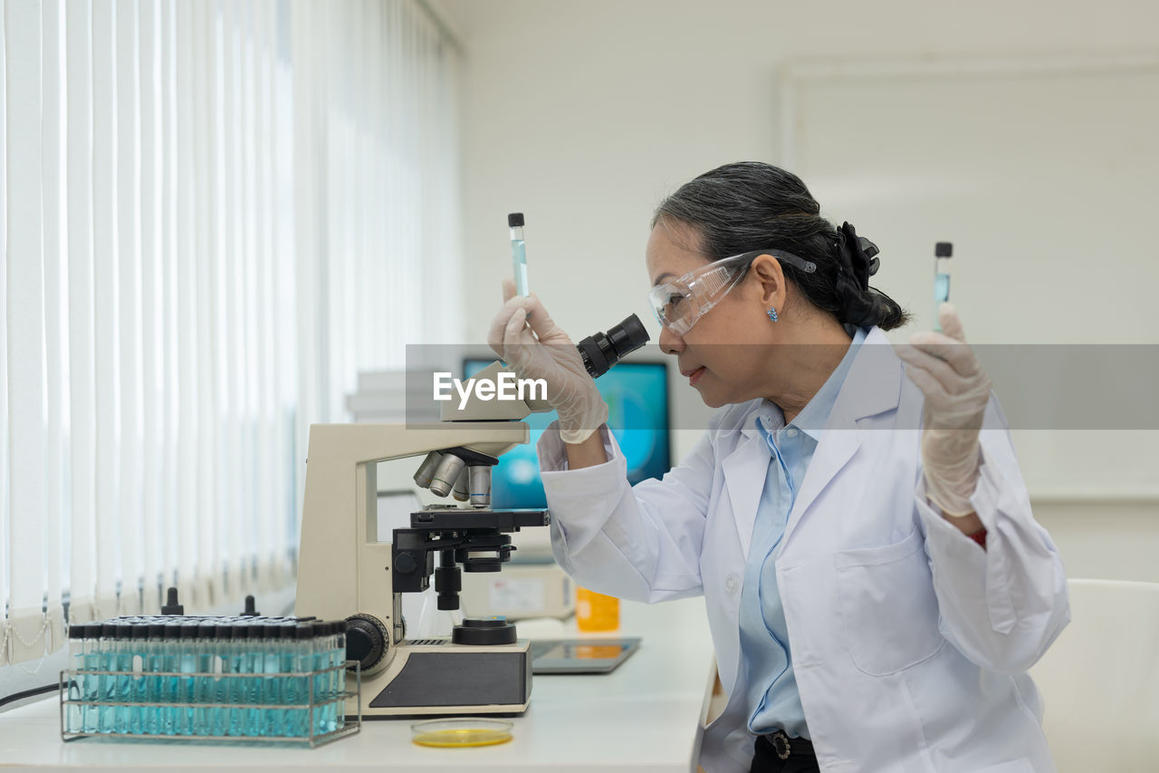 side view of female doctor examining chemical in laboratory