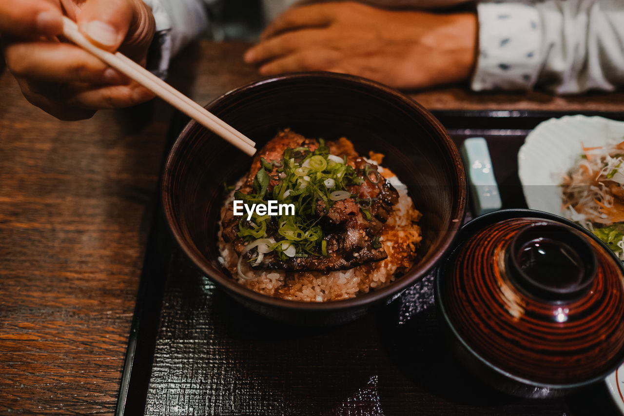 CLOSE-UP OF HAND HOLDING FOOD