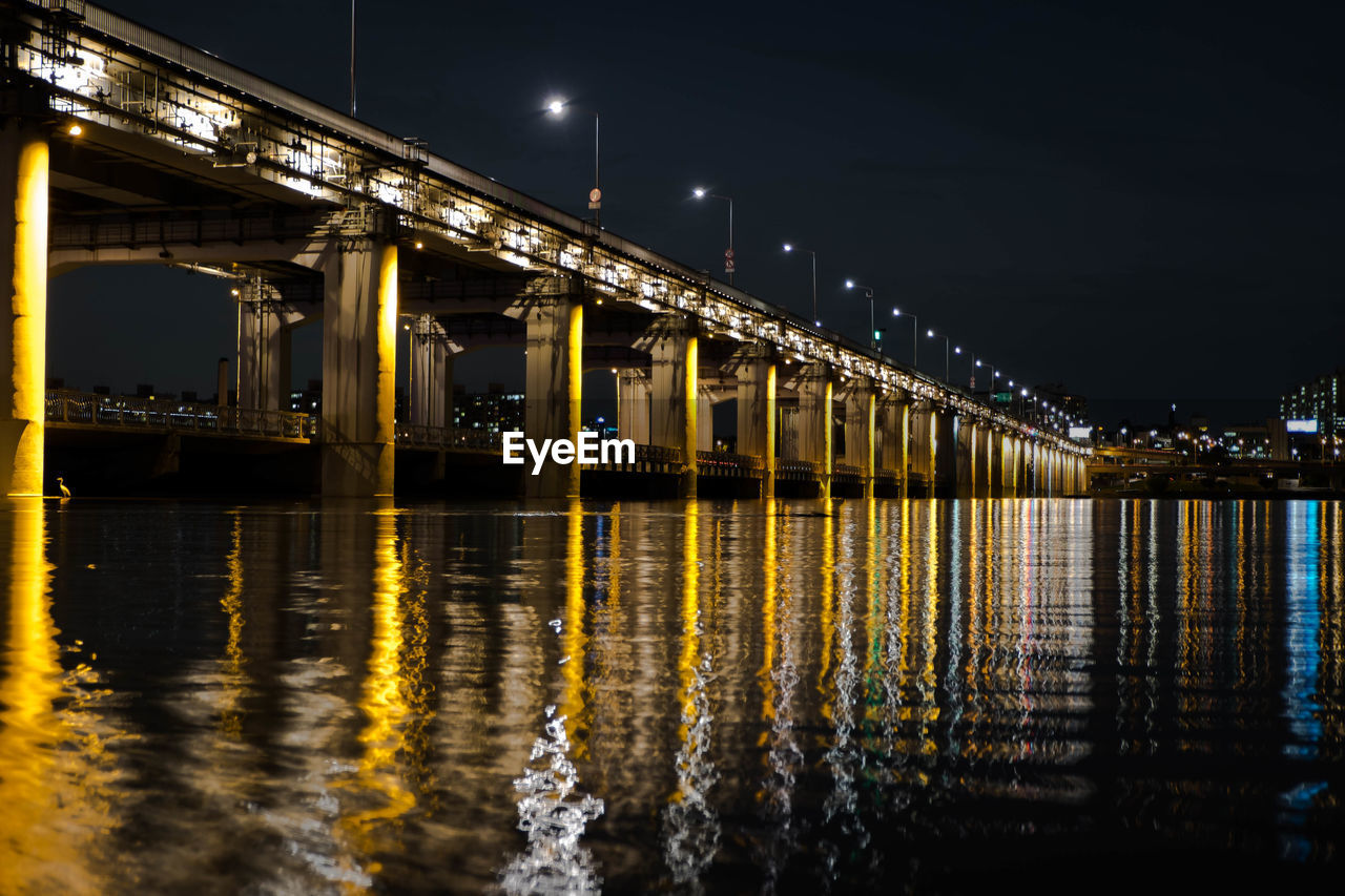 Low angle view of bridge over river at night