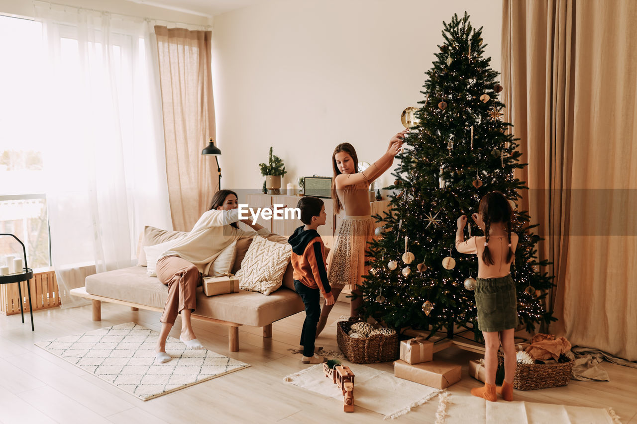 Family lifestyle. mom and kids are preparing for the christmas holidays in decorated house in winter