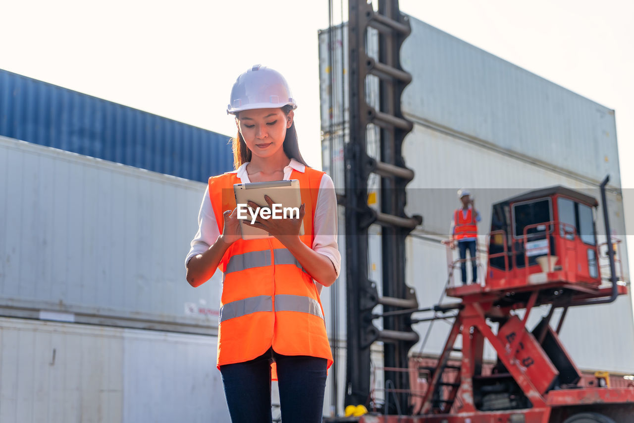 Engineers are overseeing the transportation of cargo with containers inside the warehouse.