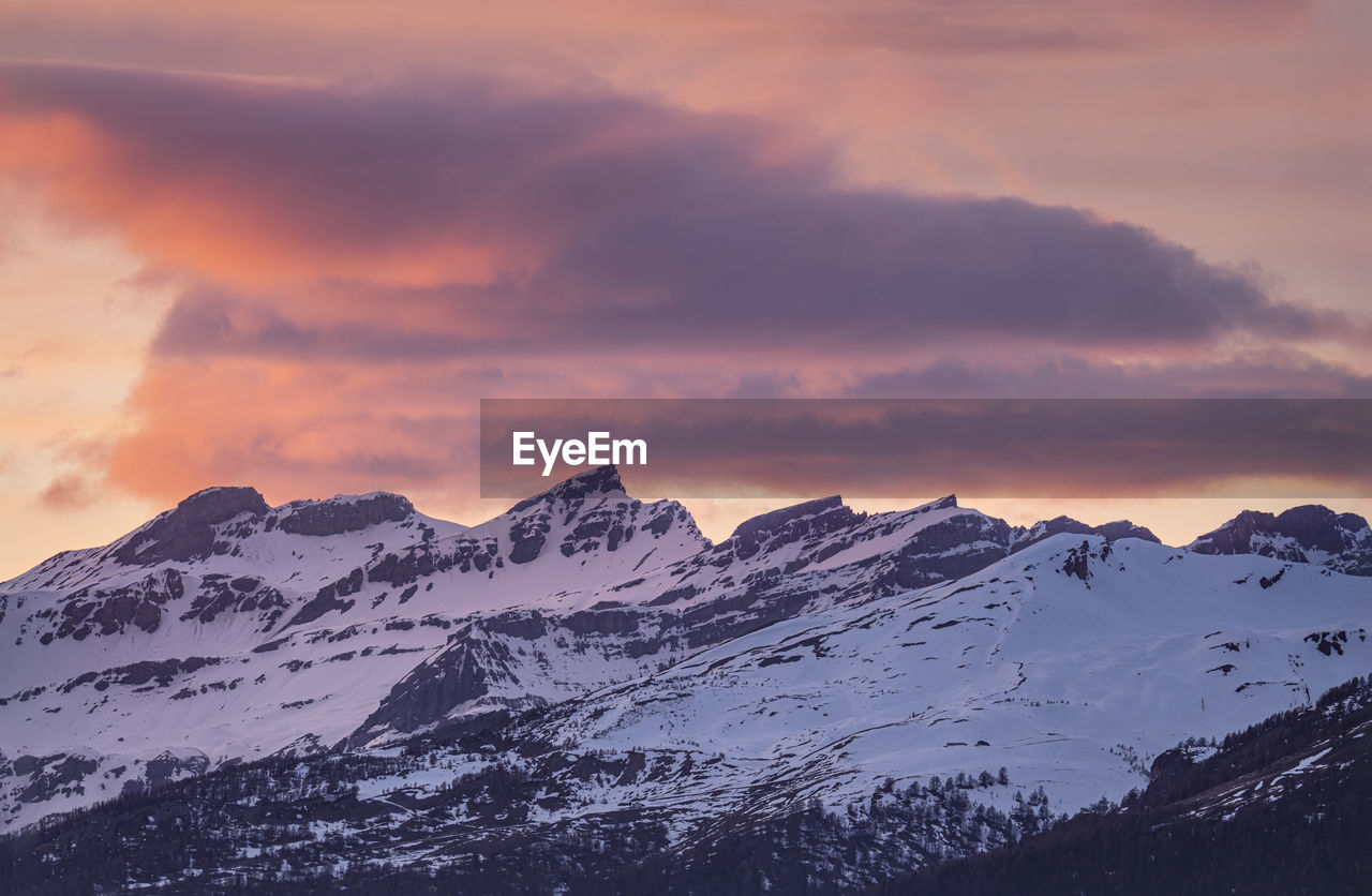 mountain, snow, winter, cold temperature, scenics - nature, sky, beauty in nature, environment, landscape, mountain range, snowcapped mountain, cloud, sunset, nature, dawn, travel destinations, mountain peak, tranquility, dramatic sky, travel, no people, tranquil scene, outdoors, tourism, idyllic, sun, non-urban scene, land, moody sky, summit, ridge, awe, vacation, dramatic landscape, extreme terrain
