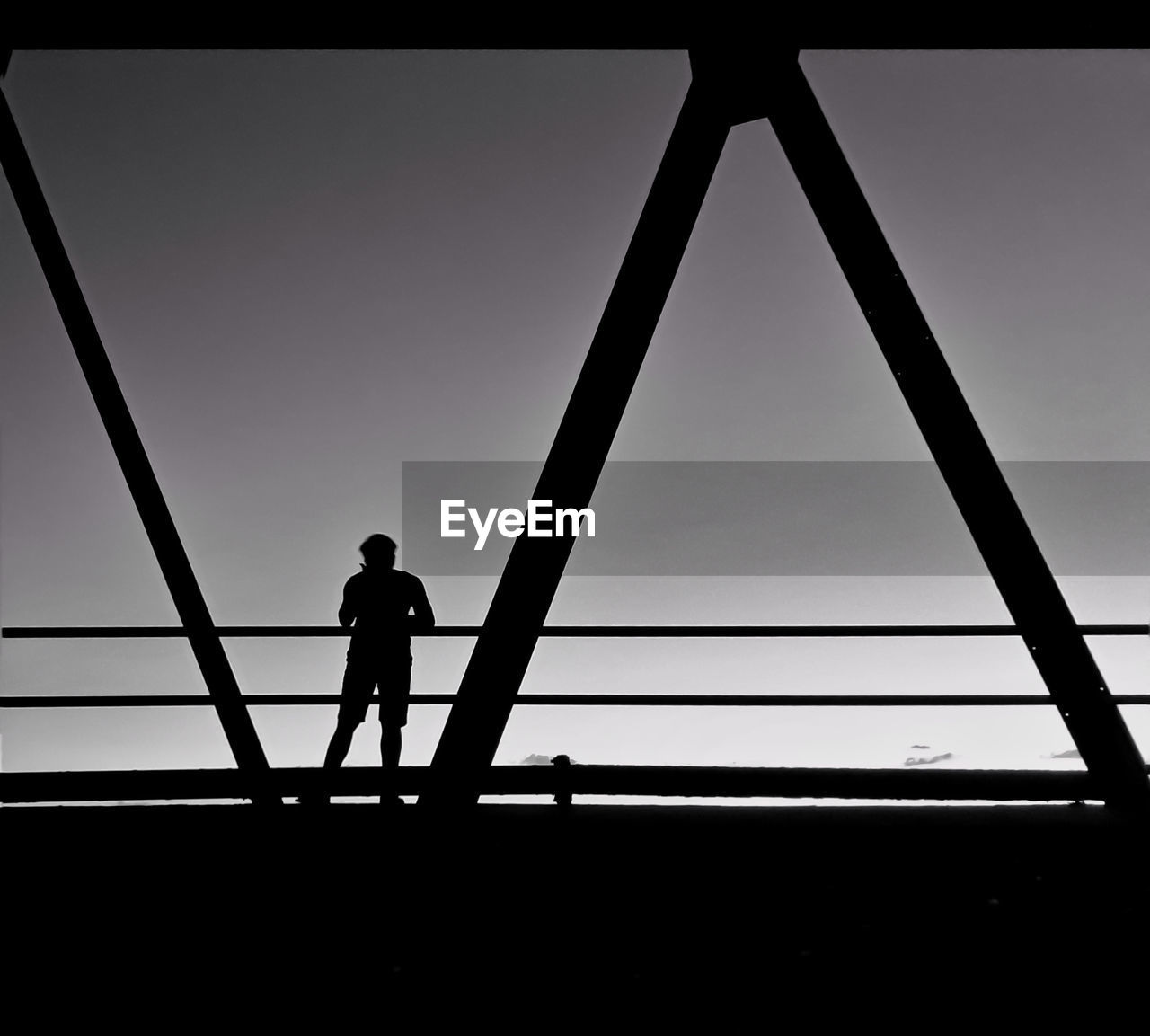 SILHOUETTE MAN STANDING AGAINST BRIDGE AGAINST SKY