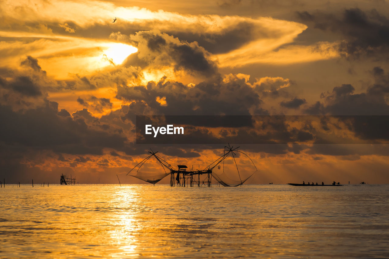 Scenic view of sea against cloudy sky during sunset