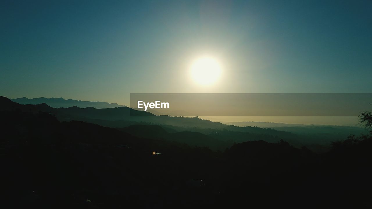 Scenic view of mountains against sky on sunny day