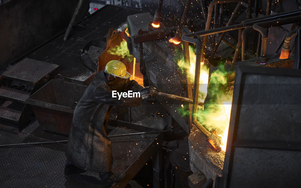 Industry, worker at furnace during melting copper, wearing a fire proximity suit