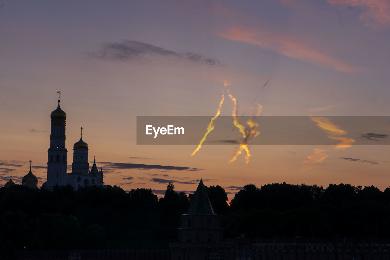 low angle view of silhouette buildings in city against sky during sunset
