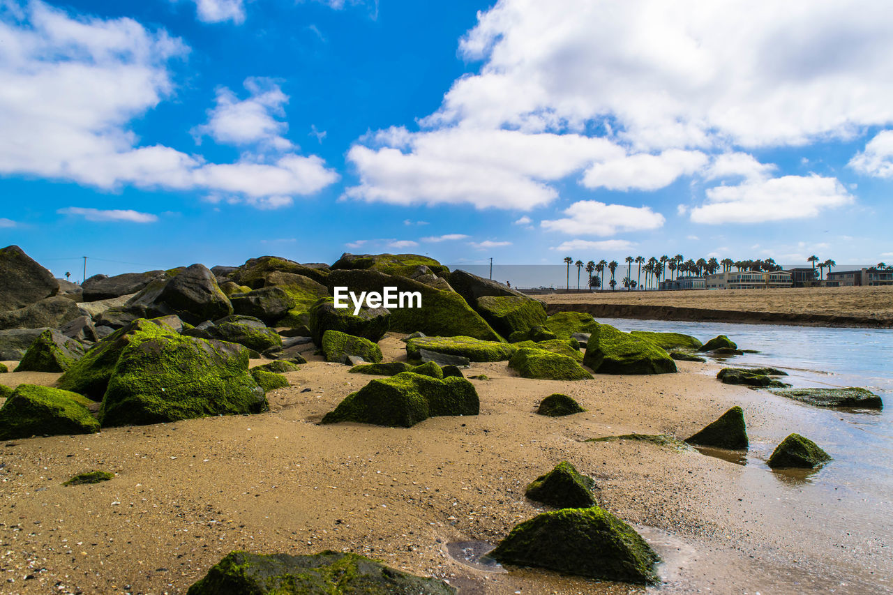 Scenic view of beach against cloudy sky