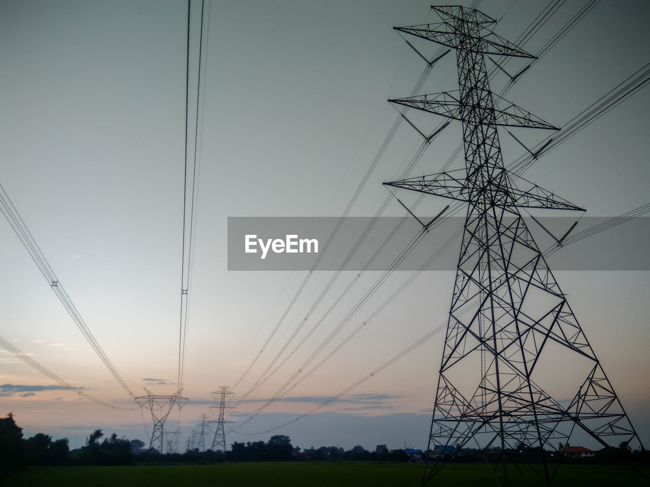 LOW ANGLE VIEW OF SILHOUETTE ELECTRICITY PYLON ON FIELD